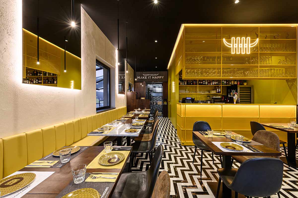 Sala interna con cubo giallo che racchiude i servizi e l angolo bar